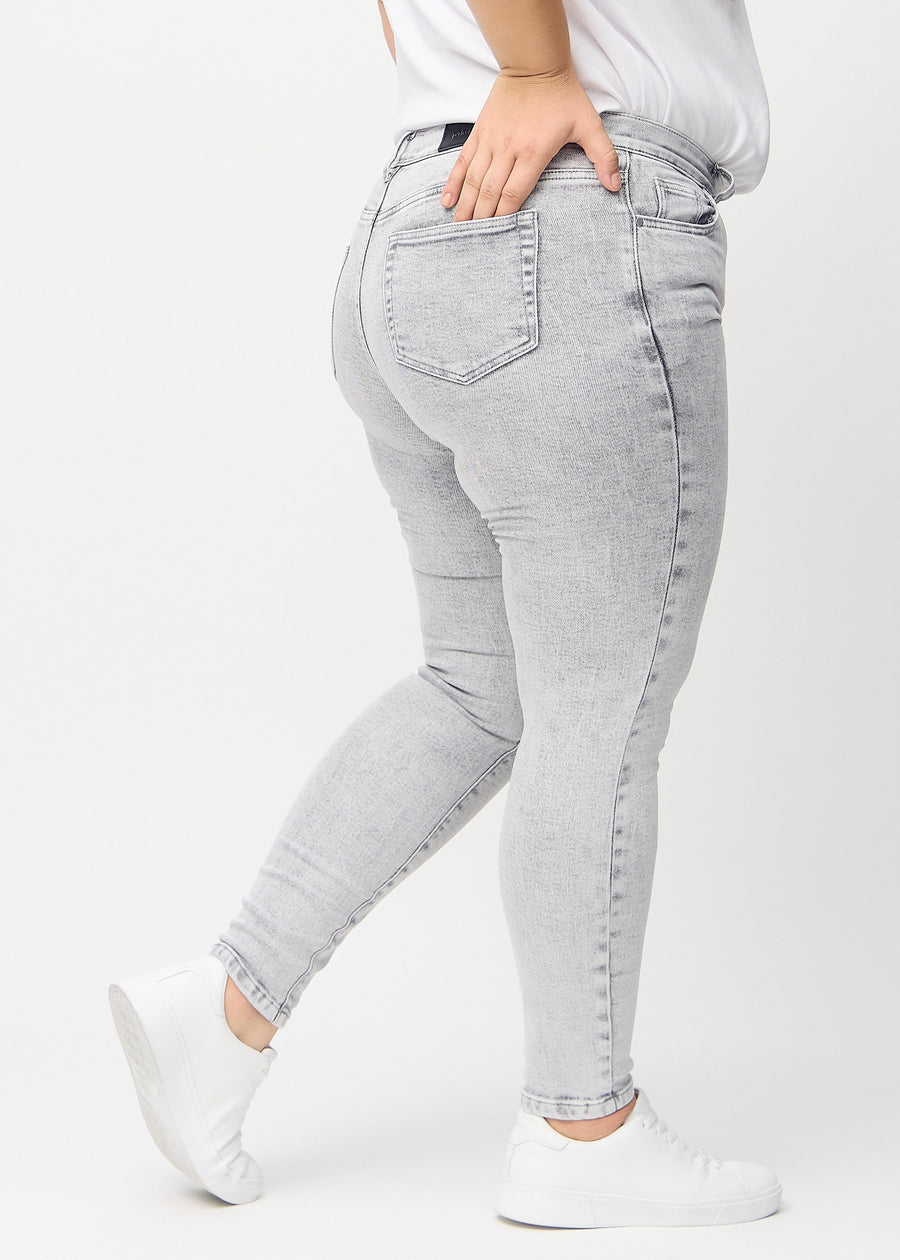 Light grey denim skinny jeans seen from the back on a plus-size model, so the entire product can be seen.
