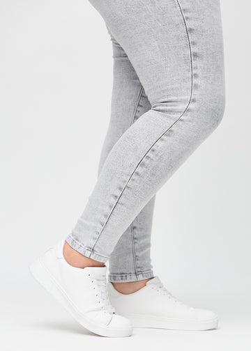 The ankles of a plus-size model, so you can see how tightly the jeans fit.