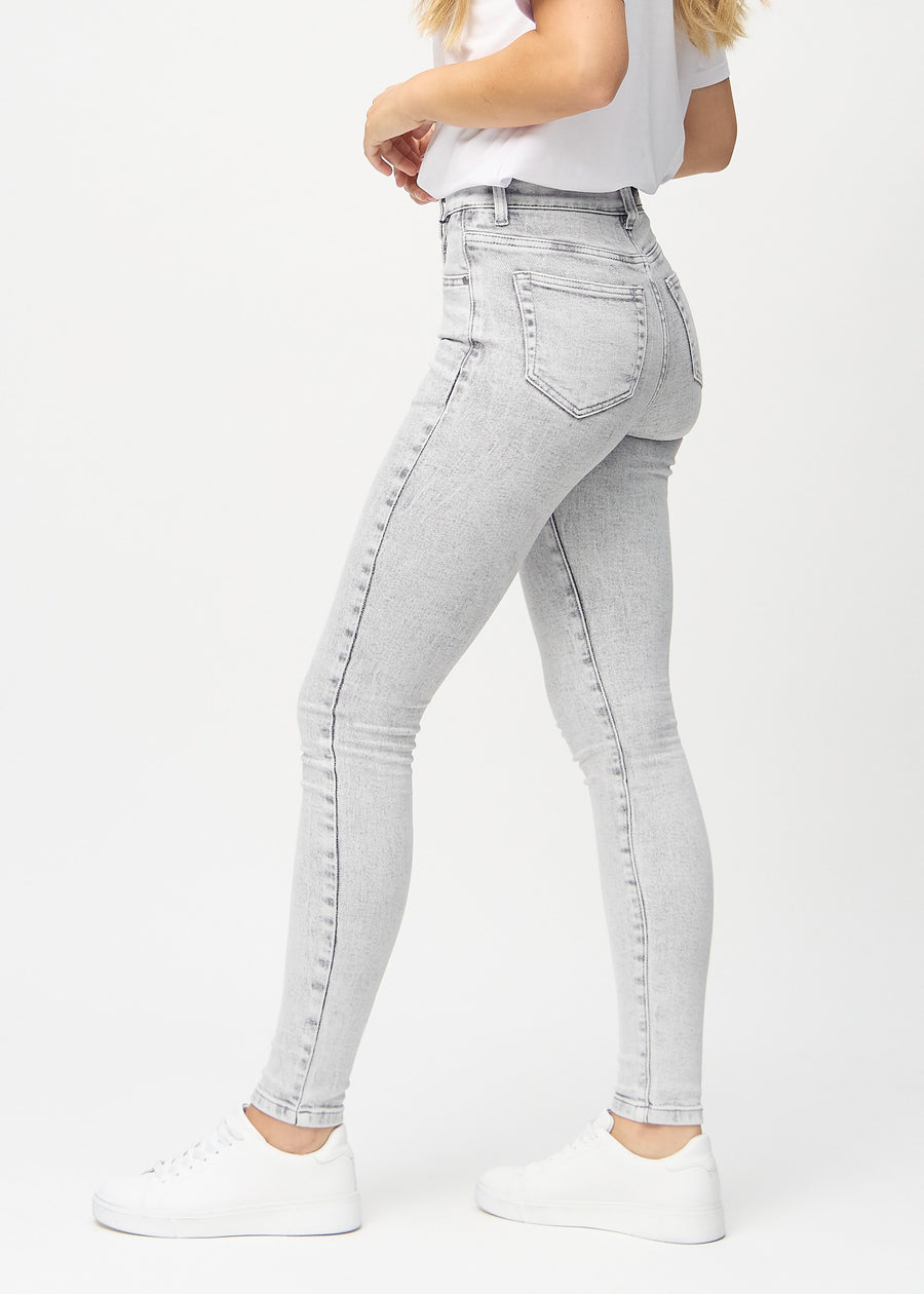 Light grey denim skinny jeans seen from the side on a model.