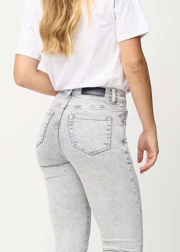 Light grey denim skinny jeans seen from the back close up to show details.