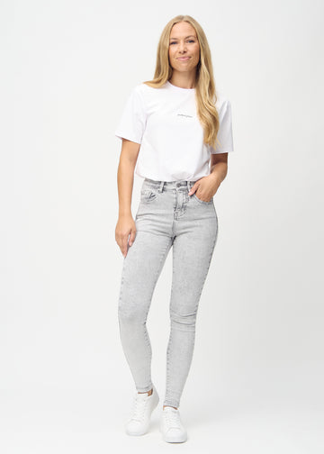 Full image of a model in light grey denim skinny jeans.