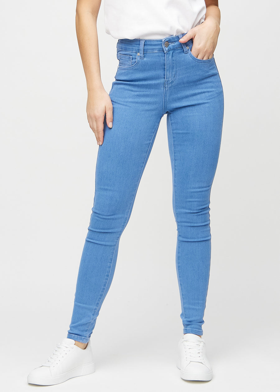 Skinny jeans for women in blue, color Geraniums. Front view on a model, showing the close fit through the legs.
