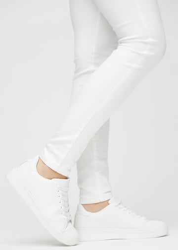 Skinny jeans for women in white, color Marguerites. Close-up of the snug-fitting leg openings at the ankles on a model.