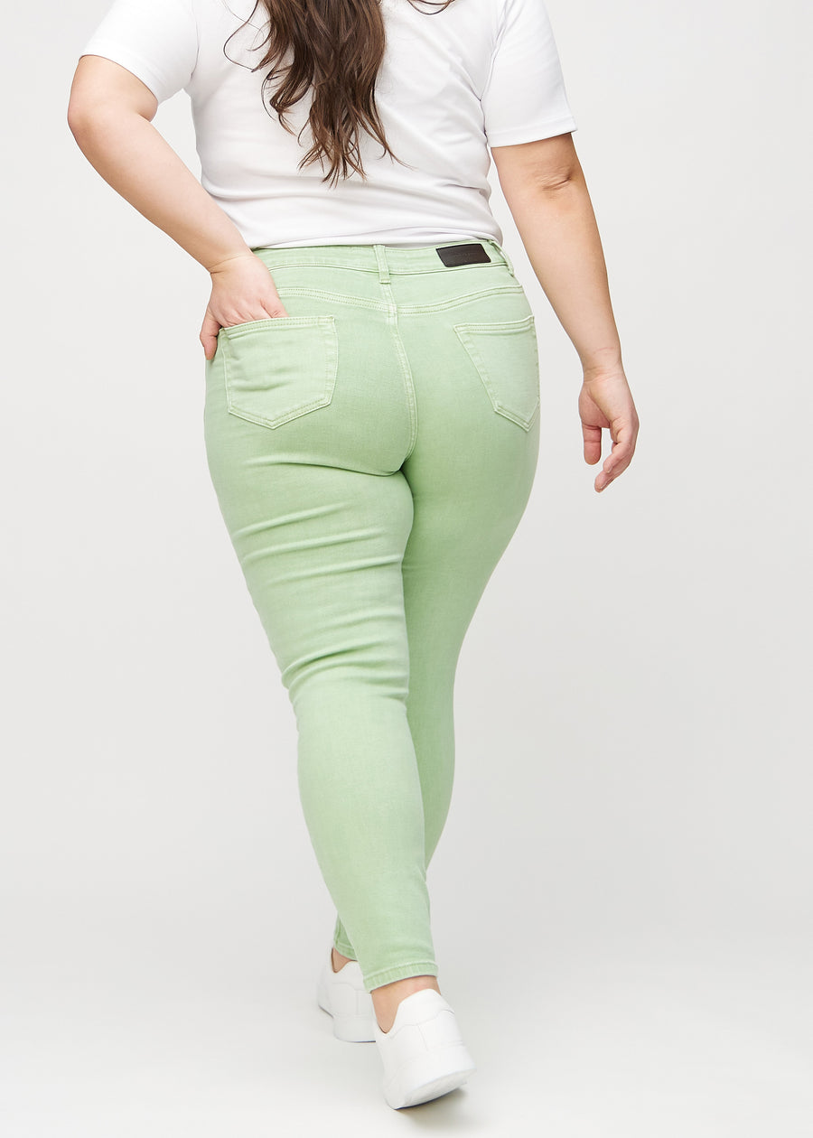 Skinny jeans for women in light green, color Mints. Back view on a plus-size model, showing the full fit.