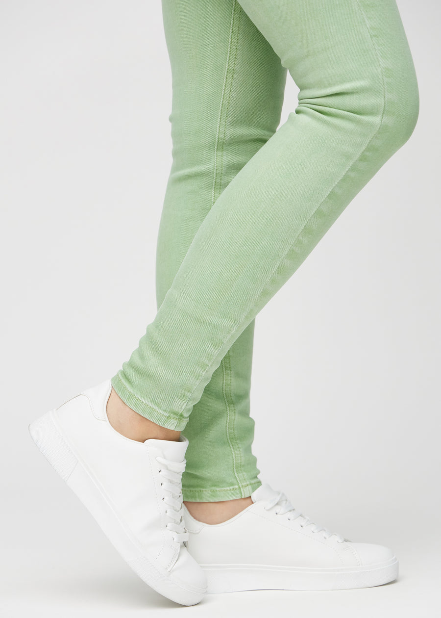 Skinny jeans for women in light green, color Mints. Close-up of the snug-fitting leg openings at the ankles on a model.