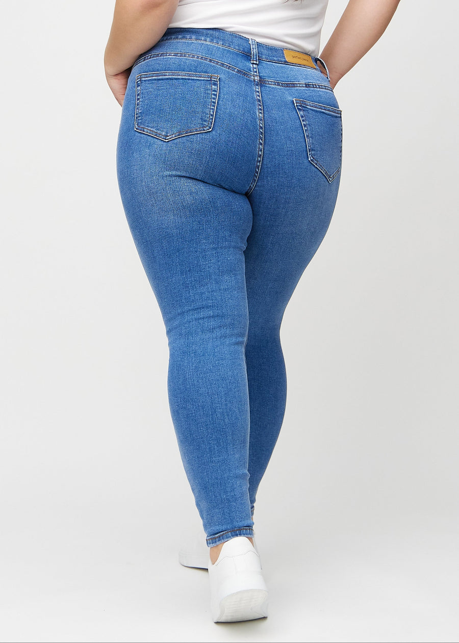 Skinny jeans for women in blue, color Rivers. Back view on a plus-size model, showing the full fit.
