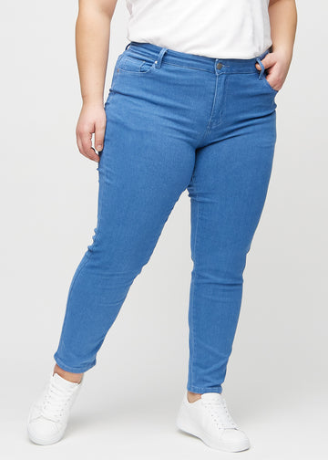 Slim jeans for women in blue, color Geraniums. Front view on a plus-size model, showing a close fit through the leg with a little more room at the ankle.
