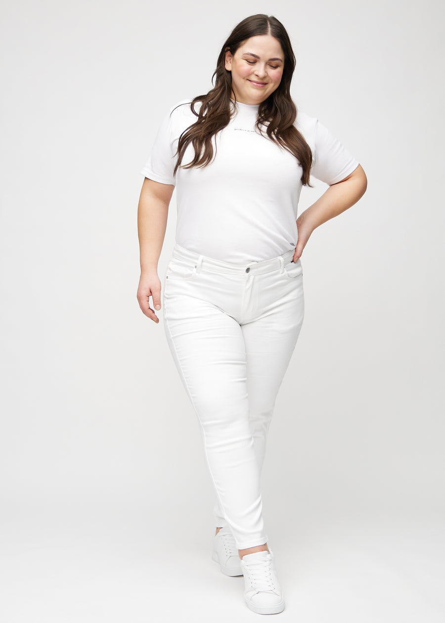 Slim jeans for women in white, color Marguerites. Full-length view of a plus-size model wearing the jeans.
