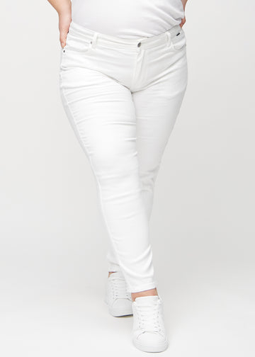 Slim jeans for women in white, color Marguerites. Front view on a plus-size model, showing a close fit through the leg with a little more room at the ankle.