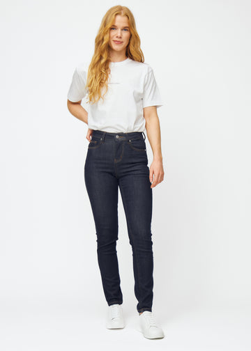 Full-length image of a model in deep dark blue denim jeans for women in the color Midnights with a slim fit.