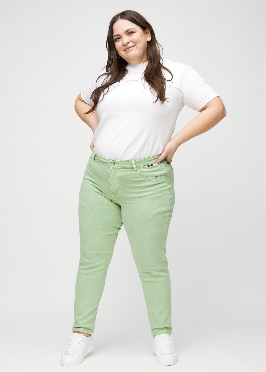 Slim jeans for women in light green, color Mints. Full-length view of a plus-size model wearing the jeans.