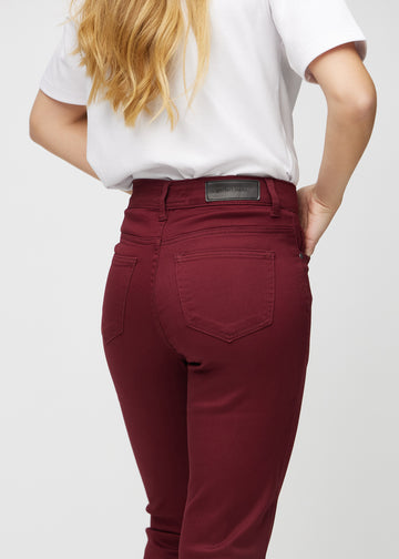 Slim jeans for women in dark red, color Santas. Close-up back view on a model, showing the details.