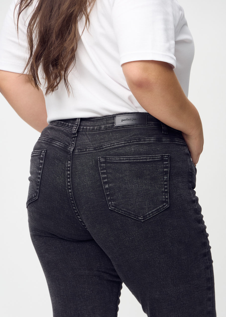 Slim jeans for women in dark grey, color Shadows. Close-up back view on a plus-size model, showing the details.