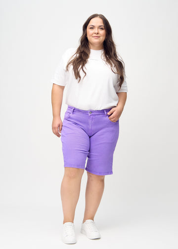 Full-length image of a plus-size model in purple regular middle shorts.