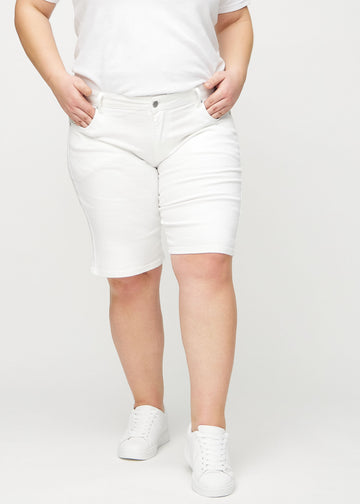 White regular middle shorts, model name Marguerites, which go straight down the leg and end just above the knee on a plus-size model, seen from the front.