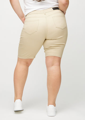 Beige skinny middle shorts seen from the back on a plus-size model, so the entire product can be seen.
