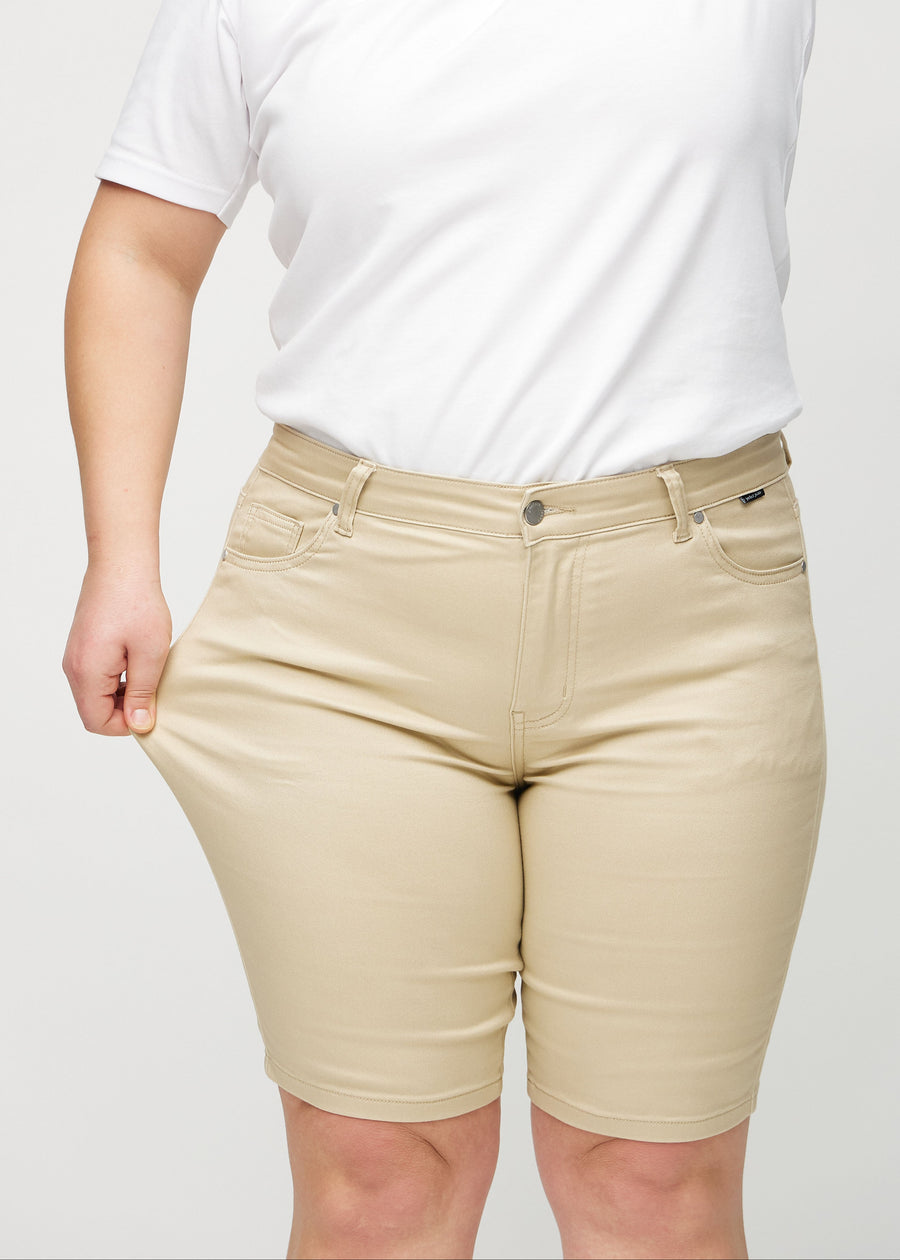 The plus-size model stretches the shorts at the thigh to show the stretch.