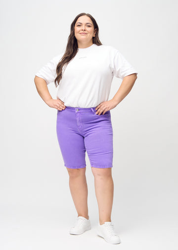 Full image of a plus-size model wearing purple skinny middle shorts.
