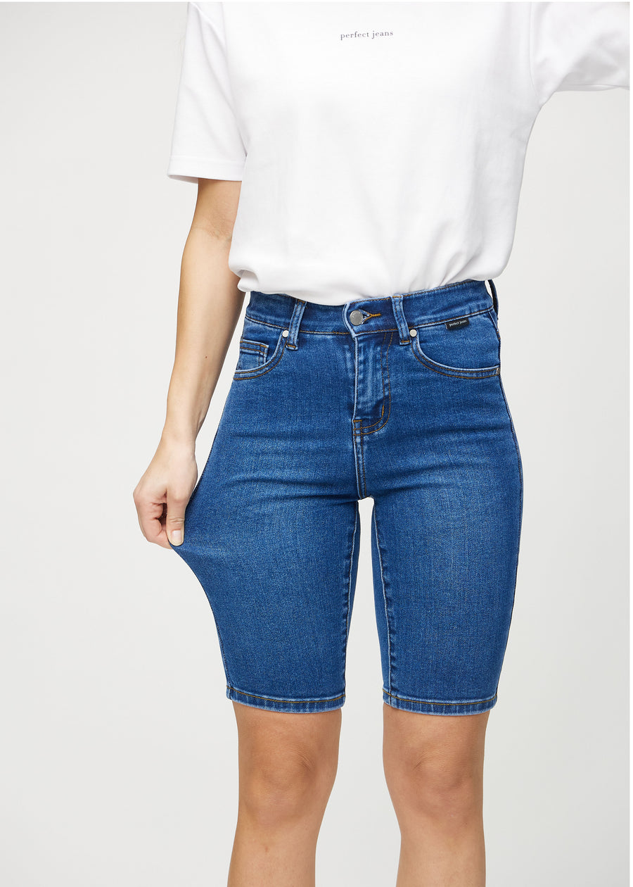 The model stretches the shorts at the thigh to show the stretch.