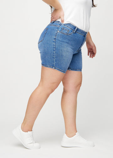 Denim skinny short shorts seen from the side on a plus-size model.