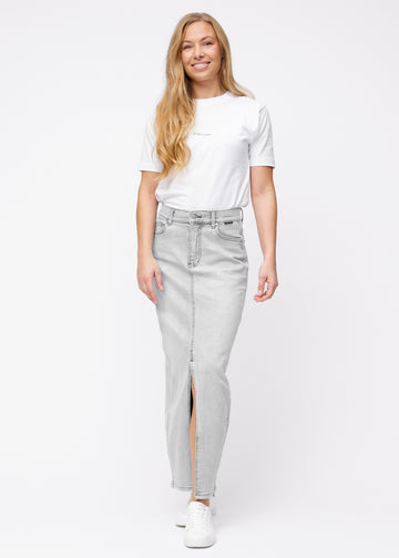 Long light grey denim skirt for women in the color Ashes. Full-length view of a model wearing the skirt with a front slit.