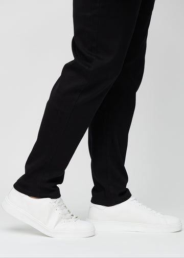 The ankles of a plus-size model, so you can see how loose the jeans fit.