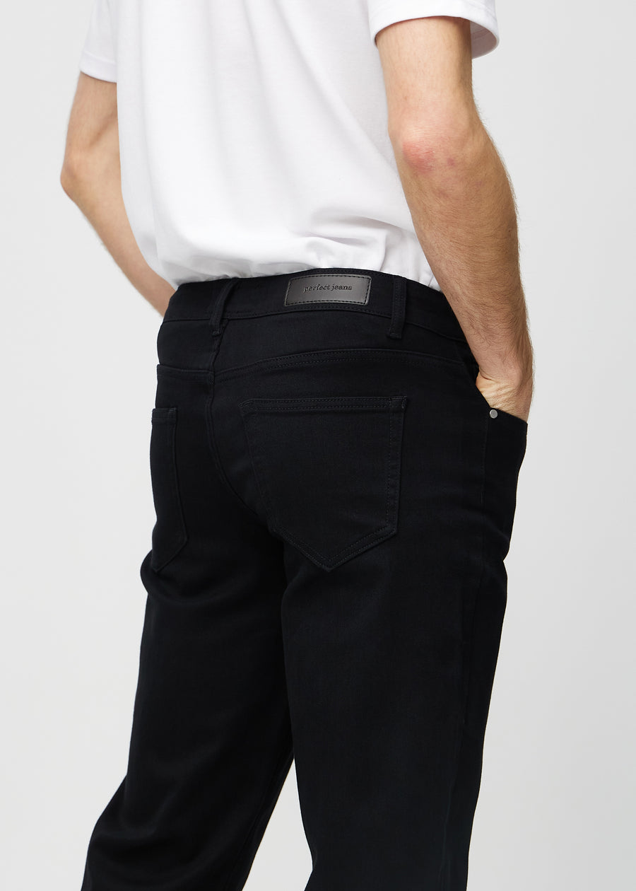 Black regular jeans seen from the back in a close-up to show details.
