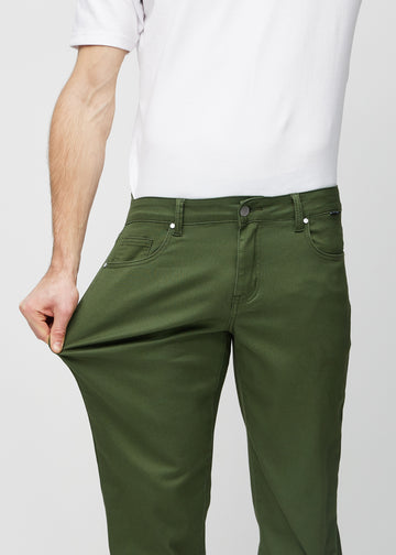 The model stretches the jeans at the thigh to show the stretch.