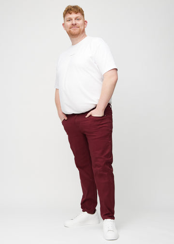 Full image of a plus-size model in dark red regular jeans.