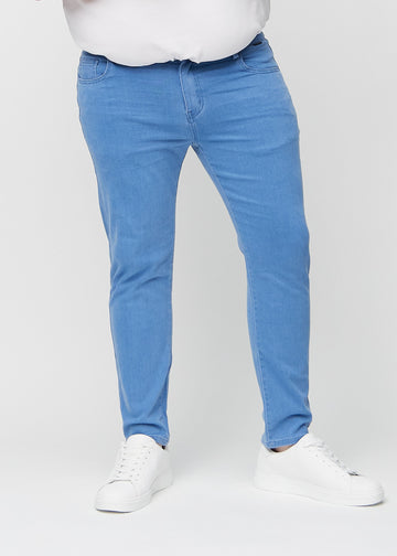 Blue slim jeans, model name Geraniums, fitted closely along the legs on a plus-size model, front view.
