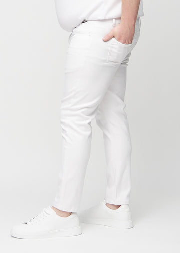 White slim jeans viewed from the side on a plus-size model.
