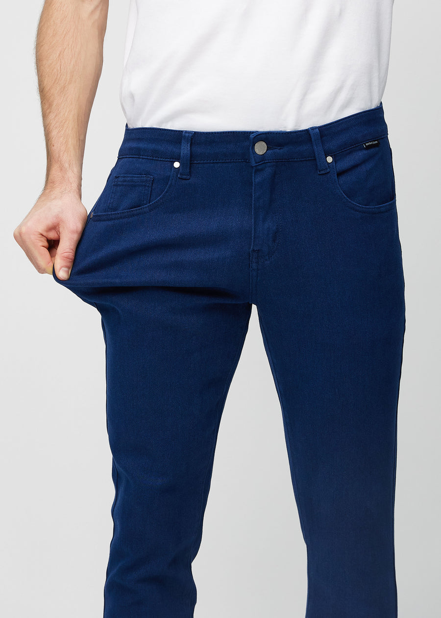 Model stretches the jeans at the thigh to show the fabric&