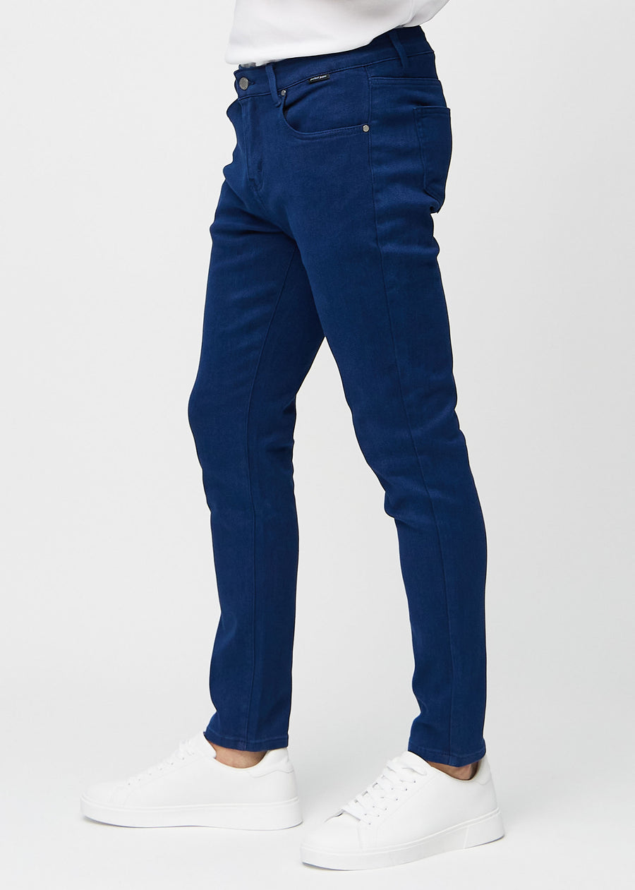 Dark blue slim jeans viewed from the side on a model.