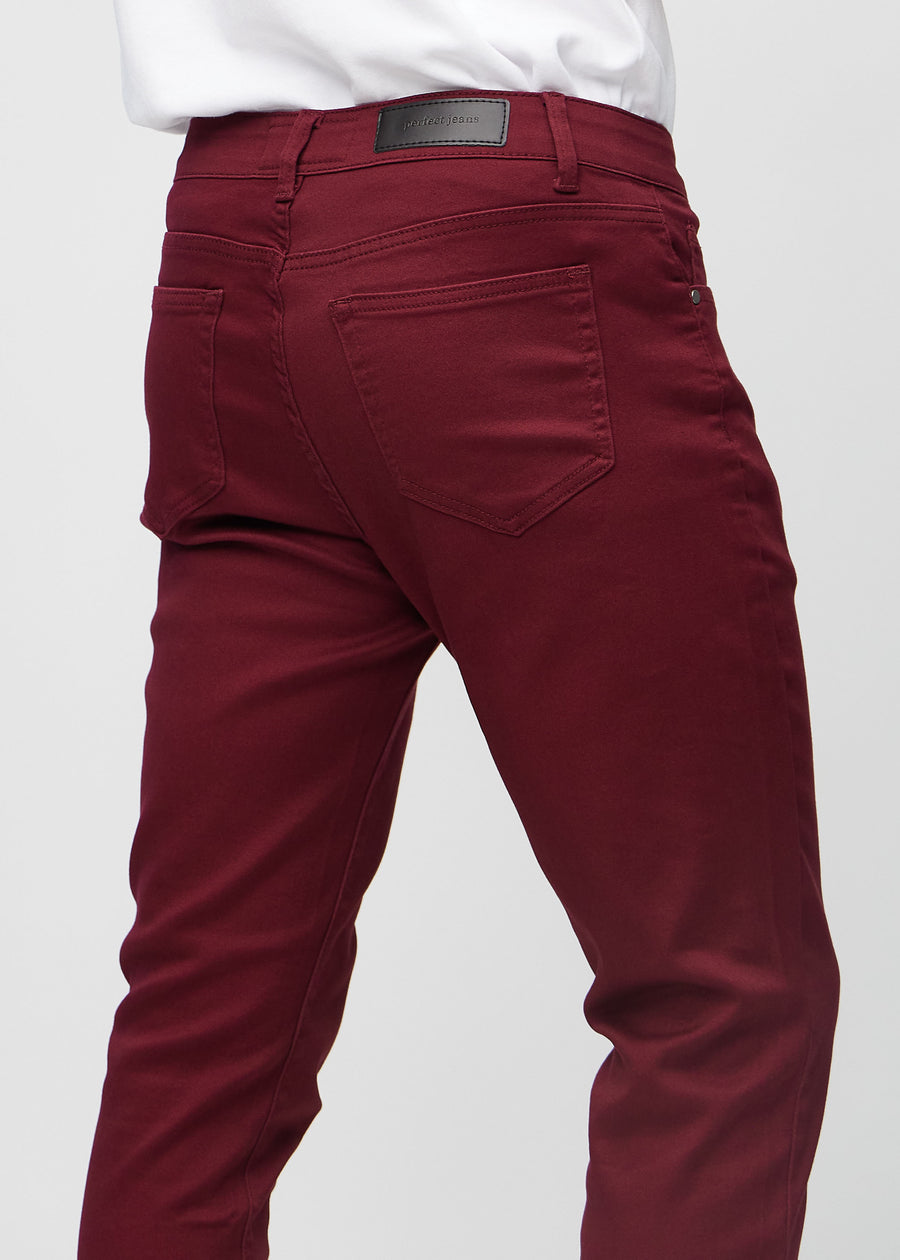 Close-up back view of dark red slim jeans showing details.