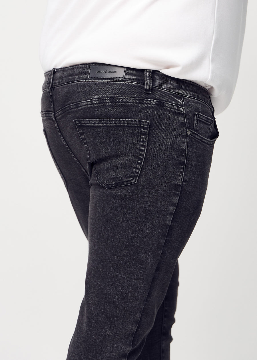 Close-up back view of dark grey denim slim jeans on a plus-size model showing details.