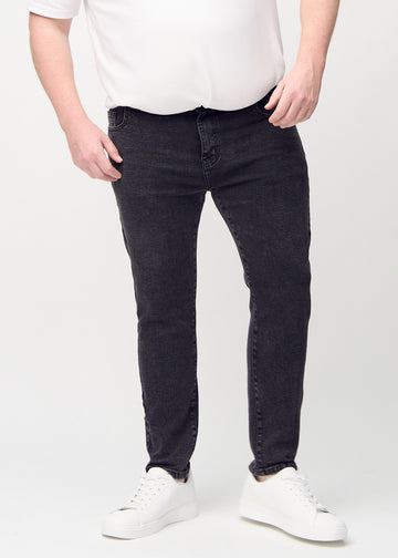 Dark grey denim slim jeans, model name Shadows, fitted closely along the legs on a plus-size model, front view.