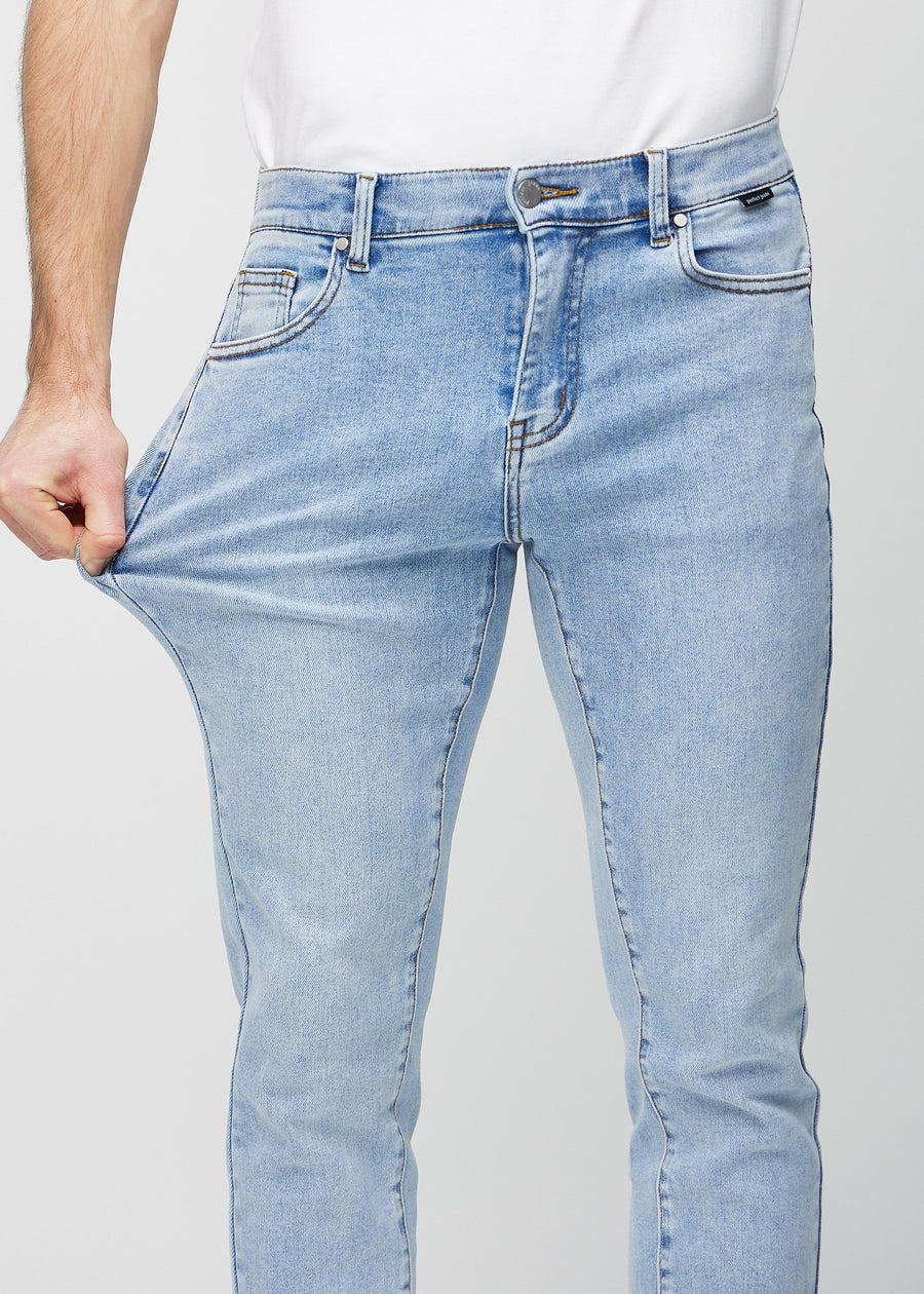 Model stretches the jeans at the thigh to show the fabric&