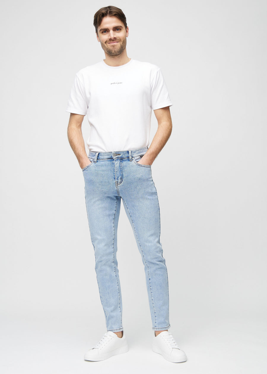 Full-length view of a model in light blue denim slim jeans.