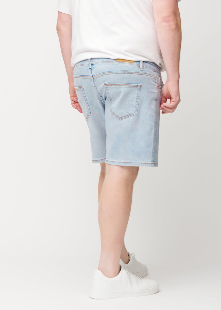 Light blue denim shorts for men in the colour Waves seen from the back on a plus-size model, so the length to just above the knee can be seen.