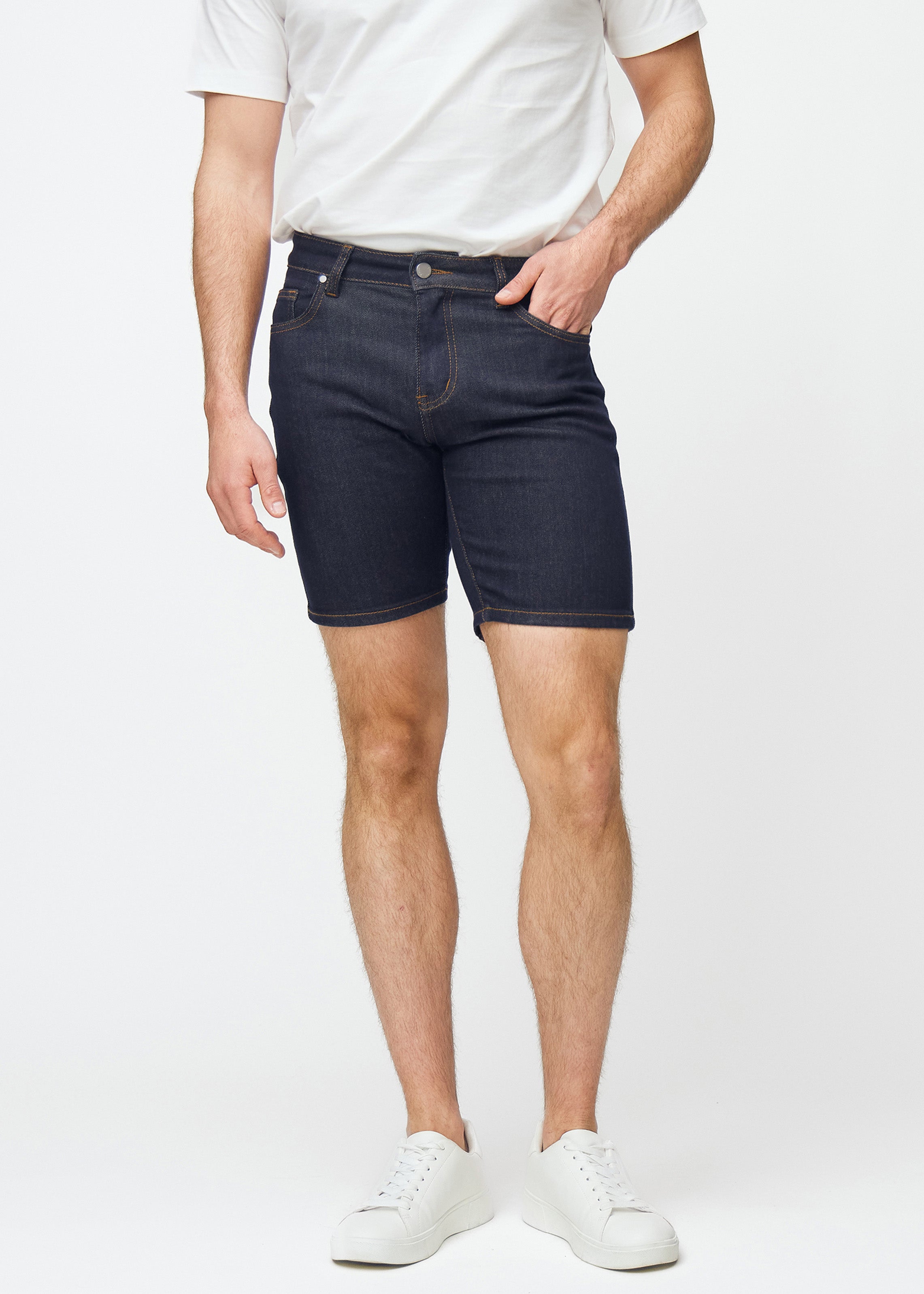 Deep dark blue denim shorts for men in the colour Midnights with a slim fit, sitting naturally at the hips and following the thighs more closely than a regular fit, seen from the front.