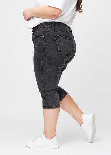 Mørkegrå denim slim capris i farven Shadows – set fra siden på en plus-size model, så man ser pasform og silhuet.