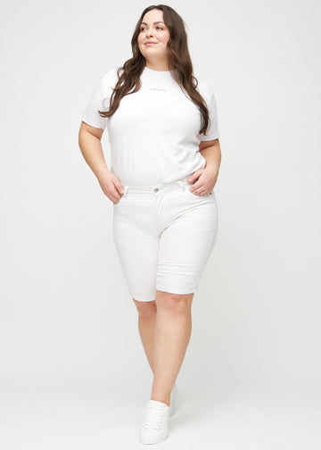 Plus-size model går ind i billedet, strækker i sine shorts, viser dem frem ved at dreje rundt, og forlader derefter billedet.