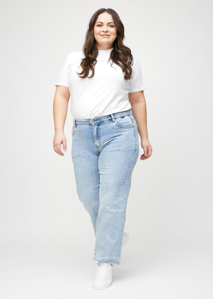 Plus-size model går ind i billedet, strækker i jeansene, viser dem frem ved at dreje rundt, og forlader derefter billedet.